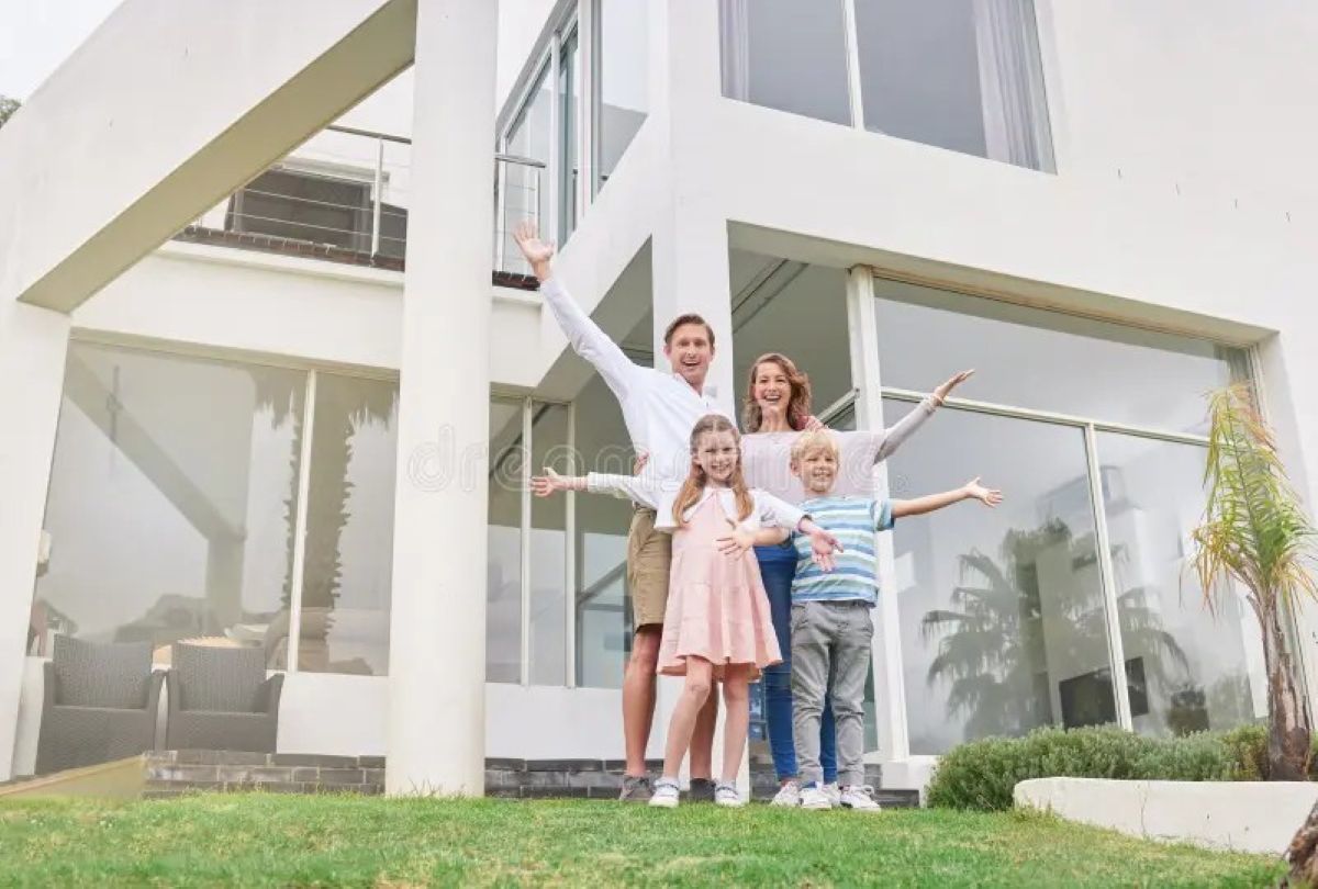 Happy family celebrating with REALTOR® in front of their new Edmonton home